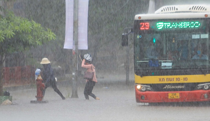 CLIP: Người dân Hà Nội vật lộn trong cơn mưa lớn trắng trời - Ảnh 9.