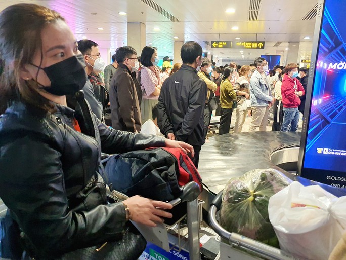 Hành khách vạ vật ở sân bay Tân Sơn Nhất rạng sáng 7-2 chờ lấy hành lý, gọi xe - Ảnh 5.