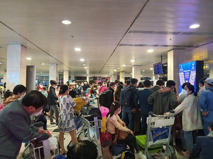 Hành khách vạ vật ở sân bay Tân Sơn Nhất rạng sáng 7-2 chờ lấy hành lý, gọi xe - Ảnh 1.