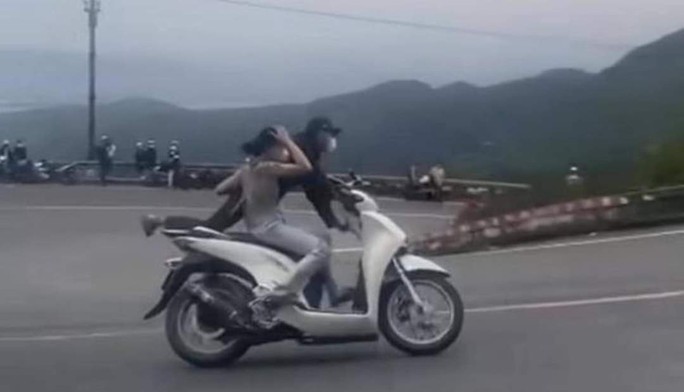 CLIP: Cặp vợ chồng đi xe máy với tư thế không giống ai trên đèo Hải Vân - Ảnh 2.
