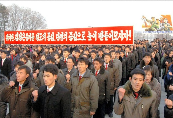 Các công nhân Triều Tiên giơ cao biểu ngữ tuyên thệ trung thành với Kim Jong-un ngày 20-12. Ảnh: Korea Central News Agency
