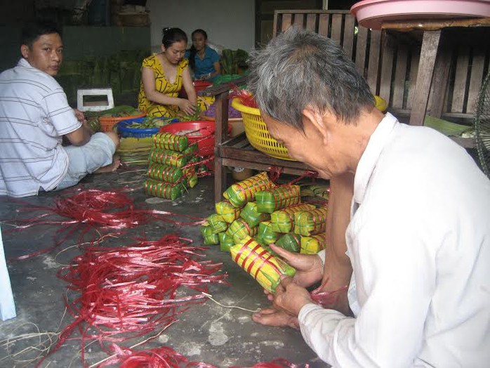 Các thành viên trong gia đình dì Chín cùng nhau gói bánh, trong đó những người đàn ông mạnh tay sẽ đảm nhận khâu cột đòn bánh