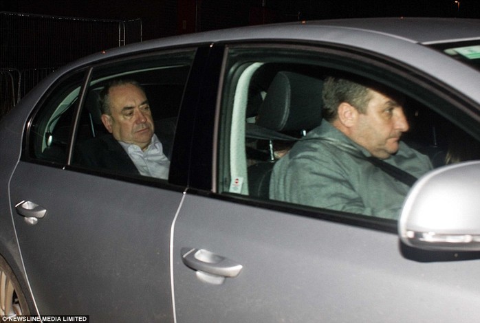 On the run: Ashen-faced First Minister Alex Salmond looked miserable as he was driven through a side gate at Aberdeen airport tonight, before boarding a private jet