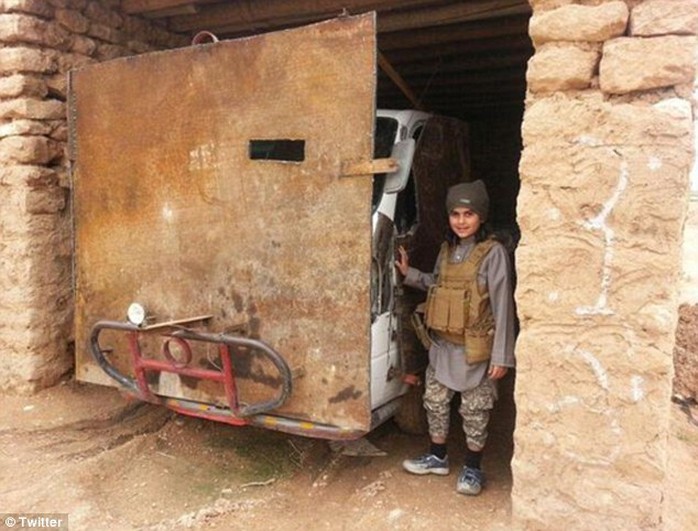 Pose: Another picture shows him smiling sweetly while wearing an ammunition vest as he stands next to a van that has been converted into an armoured vehicle with a large plank of wood and bull bars 