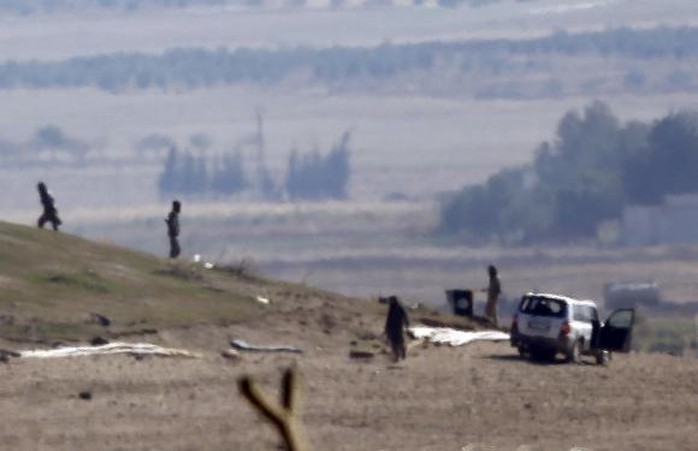 IS kiểm tra một ngọn đồi ngoại ô TP Kobane hôm 23-10. Ảnh: Reuters