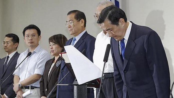 Nhà lãnh đạo Đài Loan Mã Anh Cửu (phải) cúi đầu trong một cuộc họp báo với các quan chức đảng cầm quyền sau khi Quốc dân Đảng (KMT) bị đánh bại trong cuộc bầu cử địa phương ở Đài Bắc ngày 29-11-2014. Ảnh: Reuters