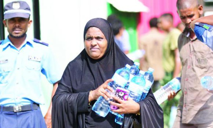 Một người dân Maldives nhận nước uống miễn phí hôm 6-12. Ảnh: AP