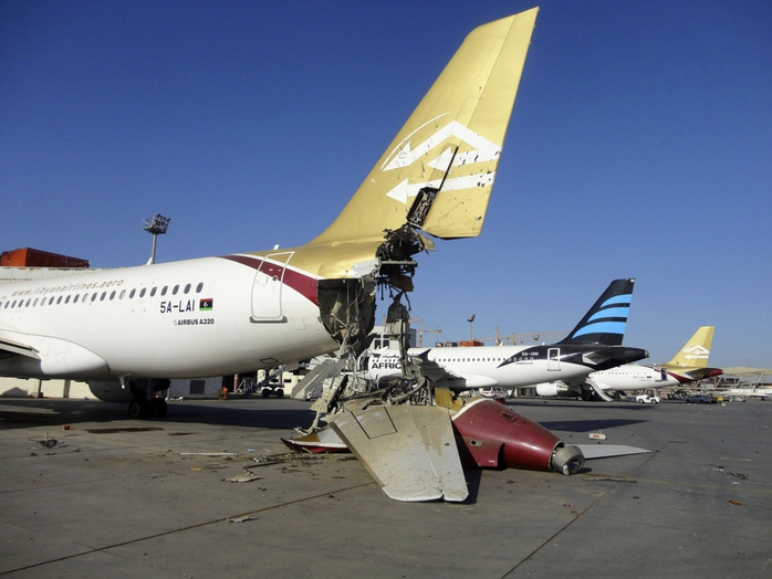Một máy bay bị phá hủy ở sân bay quốc tế Tripoli - Libya. Ảnh: Reuters