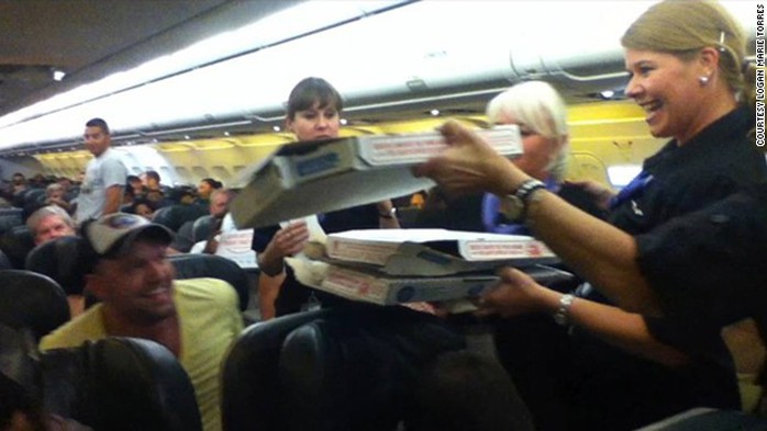 Phi hành đoàn phát pizza cho hành khách. Ảnh: CNN