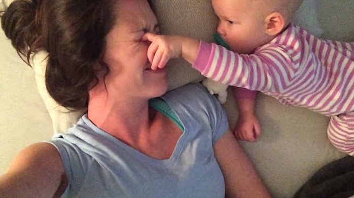 No shut eye: Baby tries poking mommys eyes so that she wakes up to play with her 