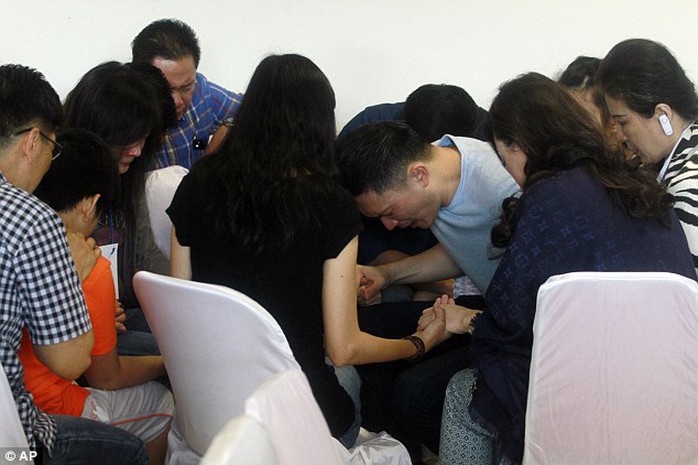 Relatives of passengers of ill-fated AirAsia flight QZ8501 pray together as they wait for the latest news on the missing jet at Juanda International Airport in Surabaya