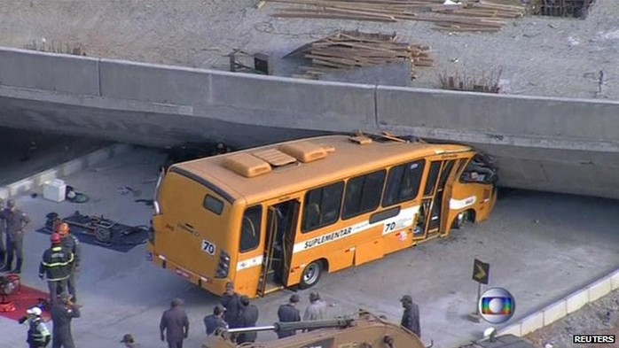 Chiếc xe buýt màu vàng bị đè nát phần đầu. Ảnh: Reuters
