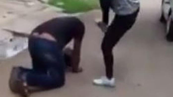 Cô gái đá vào đầu tên dê xồm khi hắn quỳ trên đất. Ảnh: Youtube