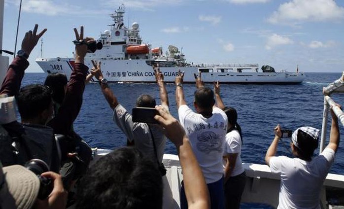 Những người trên tàu tiếp tế Philippines giơ dấu chữ V sau khi thoát khỏi tàu hải giám Trung Quốc. Ảnh: Reuters