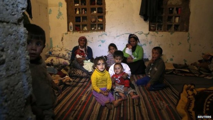 Syrian refugees from Kobane sit in a room in the south-eastern Turkish town of Suruc (13 October 2014)