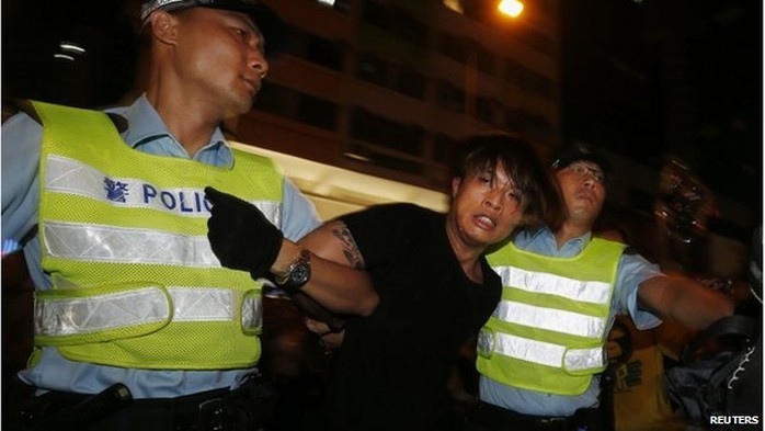 An anti-Occupy Central protester is detained by policemen after he broke through a cordon line, trying to charge pro-democracy protesters, at Hong Kongs shopping Mong Kok district, where a main road is occupied, 3 October 2014.