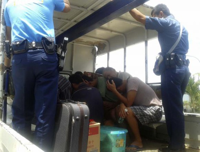 Cảnh sát biển Philippines canh chừng 11 ngư dân Trung Quốc bị bắt hôm 6-5. Ảnh: Reuters