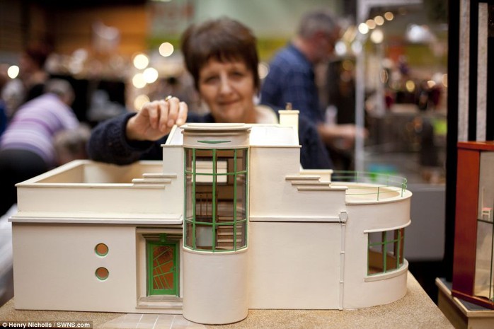 Modern style: They added: Its always good to get the Miniatura Buzz! Above, a woman poses with a cream-and-white house, which stands at just a few inches tall