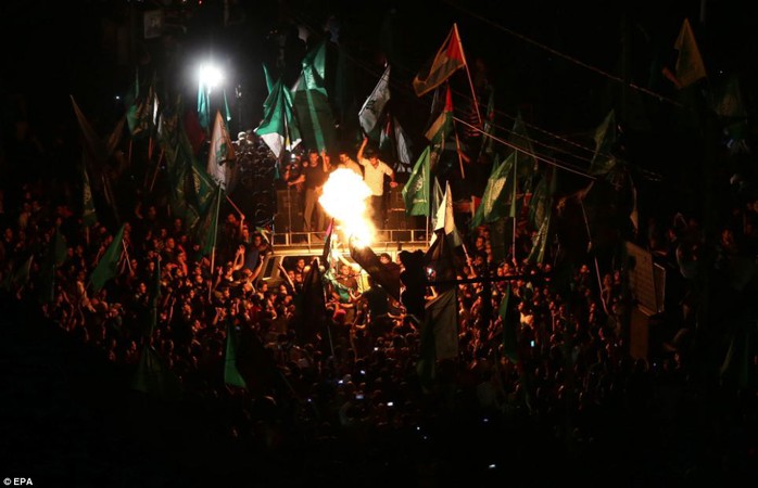 Blaze: In a month, the cease-fire calls for talks to begin in Cairo on more complex issues. Above, Palestinians gather in the streets celebrating a ceasefire in Gaza City