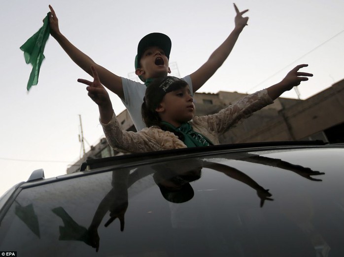 Cheerful: Young Palestinians are pictured celebrating the Egypt-brokered ceasefire, which was announced Palestinian President Mahmoud Abbas