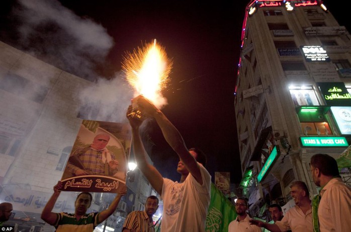 Fireworks: With missiles still being fired right up until the ceasefire deadline, doubts persisted over whether the peace would hold. Above, Palestinians launch fireworks