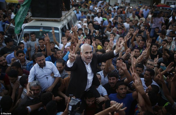 Victorious: Hamas spokesman Fawzi Barhoum (centre) is carried by Palestinians as they celebrate what they said was a victory over Israel following the ceasefire