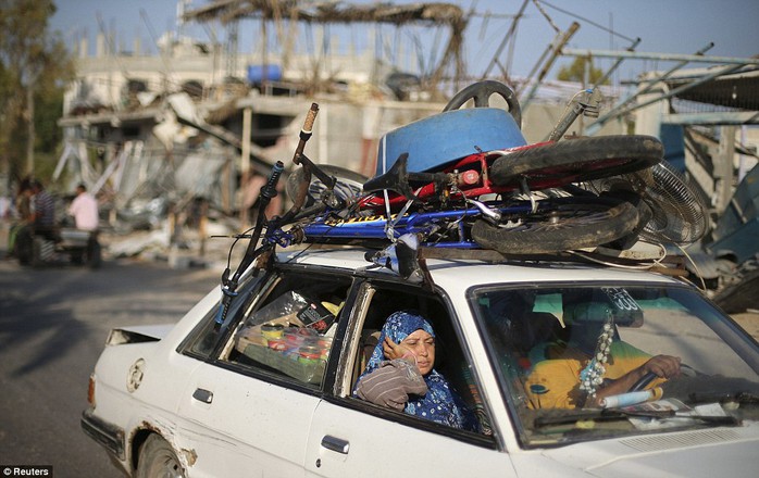 Going home: A heavily loaded car travels through the city of Beit Hanoun in the northern Gaza Strip after the ceasefire was declared. After seven weeks of fighting destroyed many buildings in the area, the truce is seen by many as a chance for life to return as normal