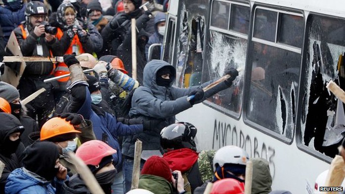 Người biểu tình tấn công hàng rào xe buýt do cảnh sát dựng lên. Ảnh: Reuters