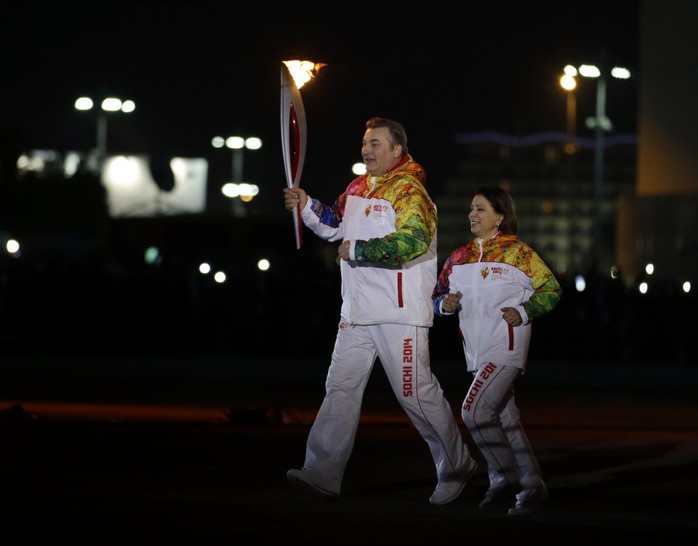 Bà Irina Rodninavà huyền thoại khúc côn cầu Vladislav Tretiak rước đuốc Olympic. Ảnh: AP