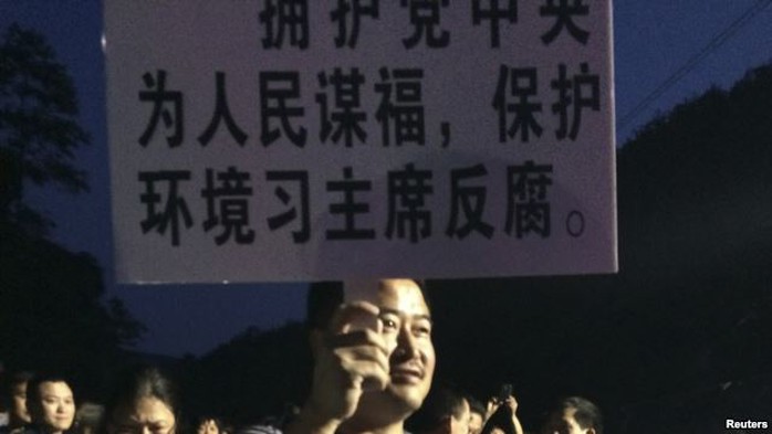 A demonstrator holds a placard during a protest against the construction of a waste incinerator in Hangzhou, Zhejiang province May 7, 2014. 