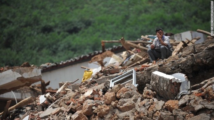 Một người đàn ông ngồi trên đống đổ nát sau trận động đất khủng khiếp hôm 3-8. Ảnh: Tân Hoa Xã
