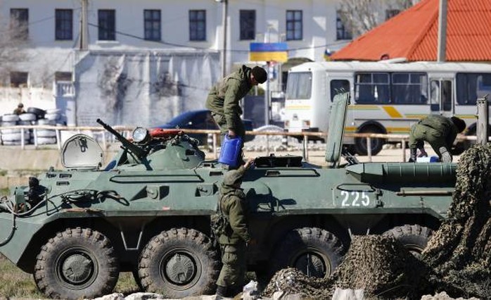 Binh sĩ Nga cùng xe bọc thép trước căn cứ hải quân Feodosia hôm 23-3. Ảnh: Reuters