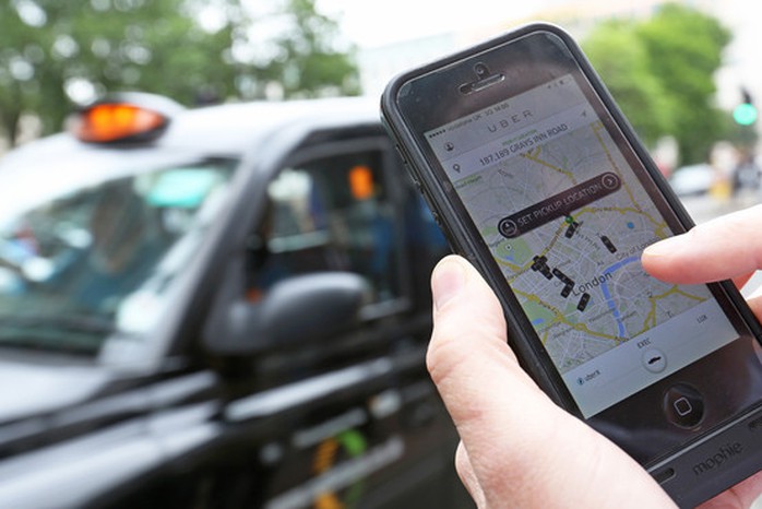 Một hành khách dùng phần mềm của Uber tìm taxi đi chung giá rẻ. Ảnh: Bloomberg