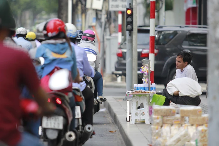 Một người khuyết tật bán tăm bông ngay ngã tư Nguyễn Thị Minh Khai-Nam Kỳ Khởi Nghĩa, quận 1 - Ảnh: Hoàng Triều