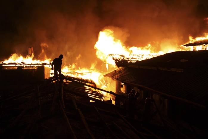 Đa số nhà đều bằng gỗ khiến lính cứu hỏa khó khăn trong việc dập lửa. Ảnh: AP