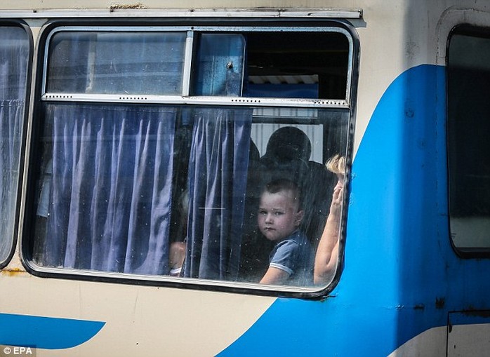 Một cậu bé trên xe buýt rời khỏi TP Donetsk hôm 13-8. Ảnh: EPA