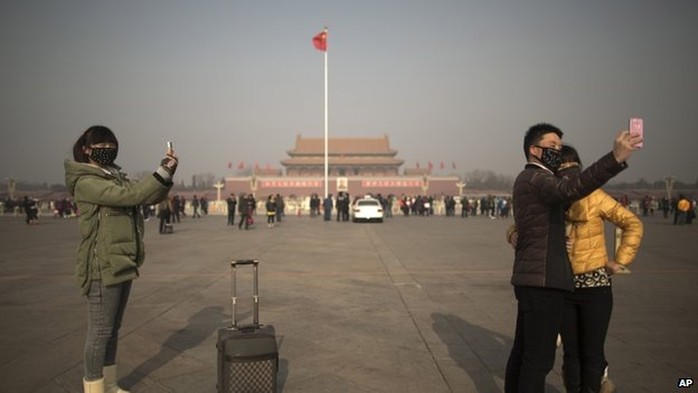 Giới chức Trung Quốc khuyên người dân ra đường nên đep khẩu trang. Ảnh: AP