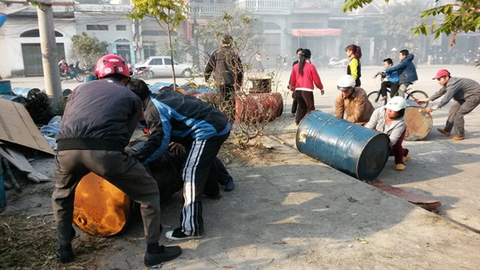 Người dân giúp chủ xưởng nến đưa thùng phuy dầu và một số tài sản khác ra khỏi xưởng nến