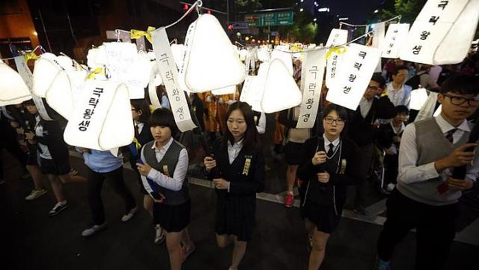 Học sinh giương cao đèn lồng cầu nguyện cho các nạn nhân trên tàu Sewol ngày 26-4. Ảnh: REUTERS