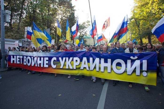 Người biểu tình mang cờ Ukraine, trang trí băng-rôn với khẩu hiệu để phản đối Nga can thiệp vào Ukraine. Ảnh: AP