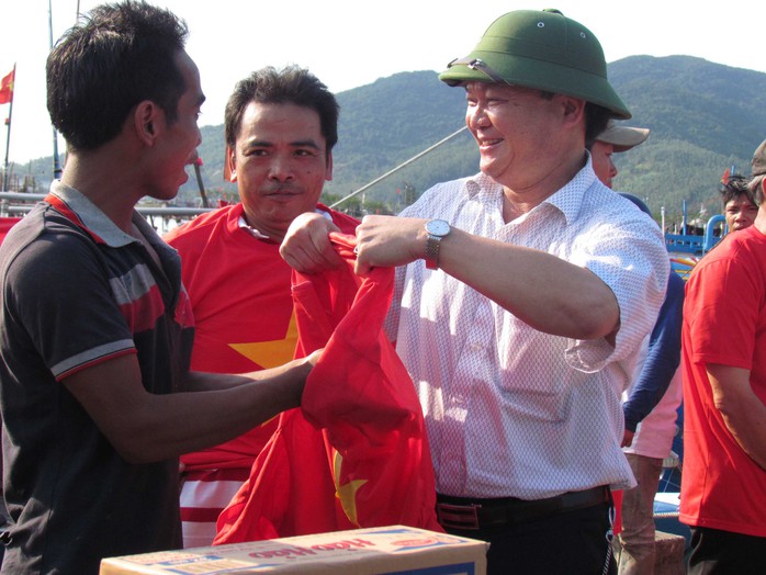 Đại diện Hội Doanh nghiệp quận Hải Châu, TP Đà Nẵng trao áo mang màu cờ đỏ sao vàng cho ngư dân trước khi ra khơi