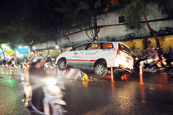 Chiếc taxi bả chỗ mất lái leo lên dải phân cách cao hơn nửa mét, rất may tài xế và 3 hành khách không bị thương