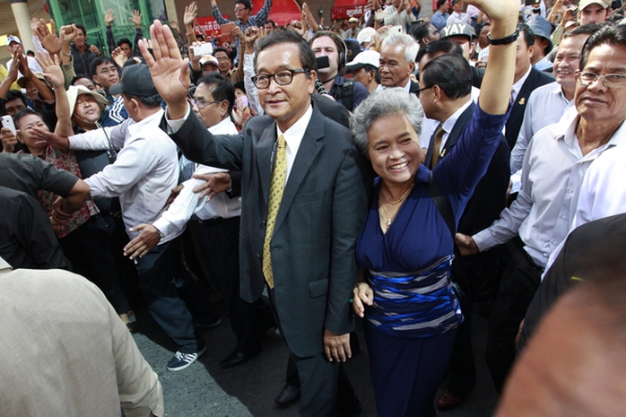 Ông Sam Rainsy, lãnh đạo Đảng CNRP, vẫy tay chào người ủng hộ bên ngoài tòa án. Ảnh: EPA