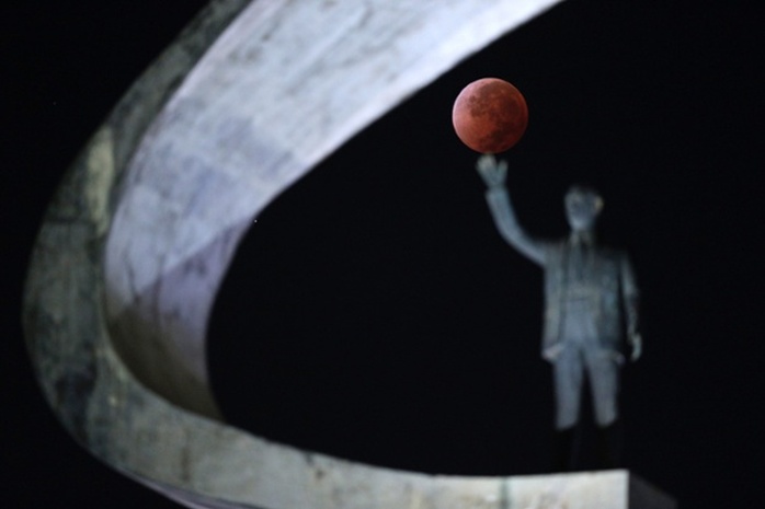 Mặt trăng nằm gọn trong tay bức tượng ở thủ đô Brasilia, Brazil. Ảnh: Reuters