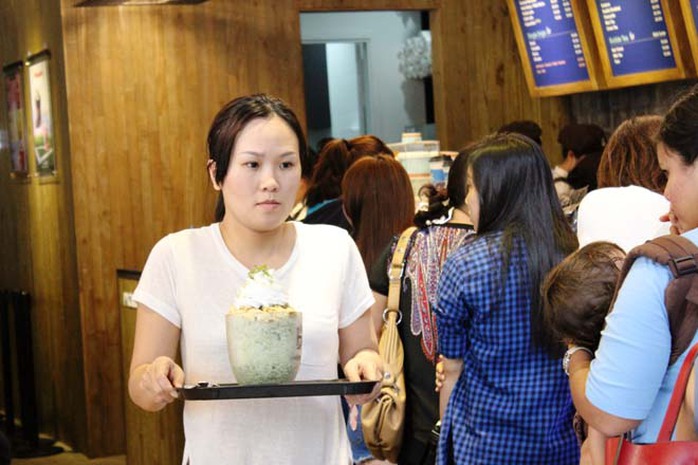 Một khách hàng đang cố gắng tìm một vị trí ngồi sau khi mua được ly cà phê 'khổng lồ' Một khách hàng đang cố gắng tìm một vị trí ngồi sau khi mua được ly cà phê khổng lồ