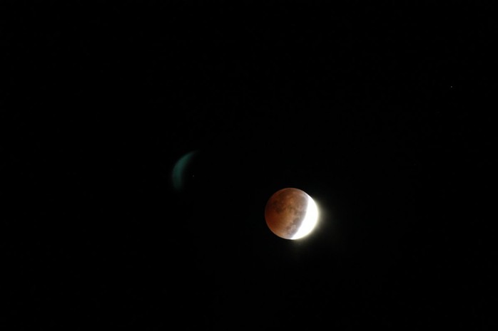 Mặt trăng đỏ lòm trên hồ Michigan. Ảnh: Corey Seeman/ Flickr