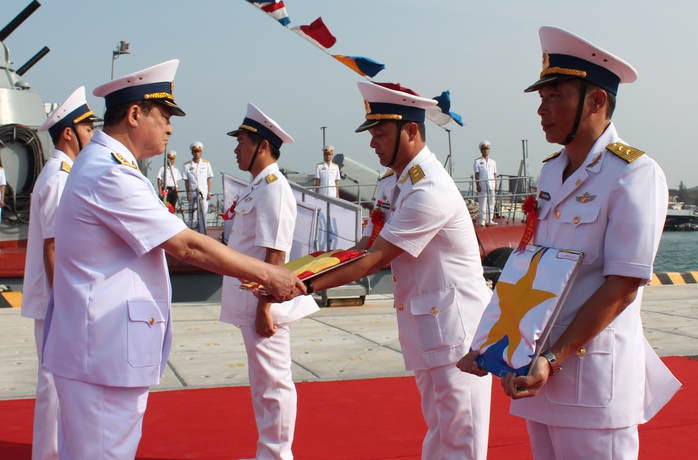 Đô đốc Nguyễn Văn Hiến trao quốc kỳ cho đại diện cán bộ, thủy thủ Tàu ngầm HQ-182 Hà Nội