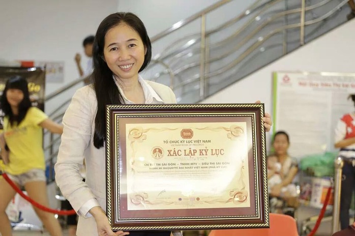 Bà Lê Minh Trang - Tổng Giám đốc Tổng Công ty Thương mại Sài Gòn (SATRA) chụp hình lưu niệm cùng

bằng xác lập kỷ lục chiếc bánh mì dài nhất Việt Nam của Siêu thị Sài Gòn