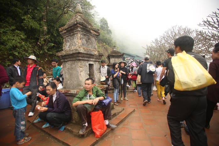 Người dân dự lễ hội nghỉ chân bên những ngôi tháp cổ ở chùa Hoa Yên