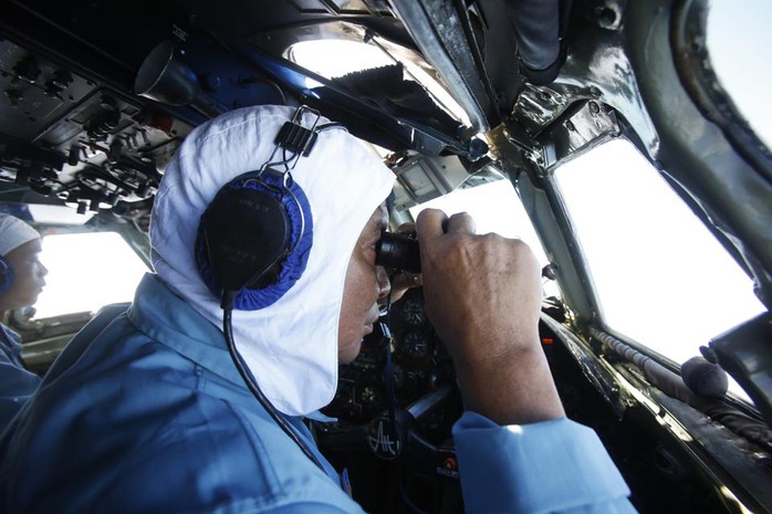 Thiếu tá Nguyễn Tri Thức, Trung đoàn Không quân 918, từ trên chiếc AN26 dùng ống nhòm tìm kiếm chiếc máy bay Malaysia mất tích - Ảnh: Reuters
